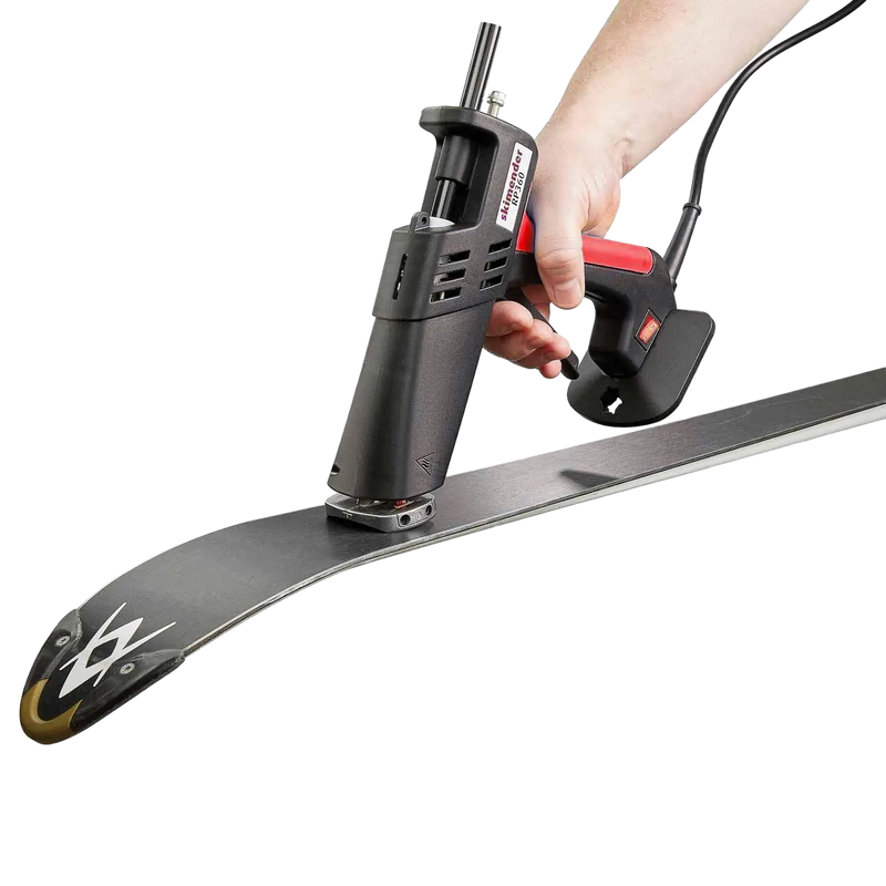 Load image into Gallery viewer, Hand hält elektrisches Werkzeug mit rotem Griff und schwarzem Gehäuse über der Spitze eines Skis.