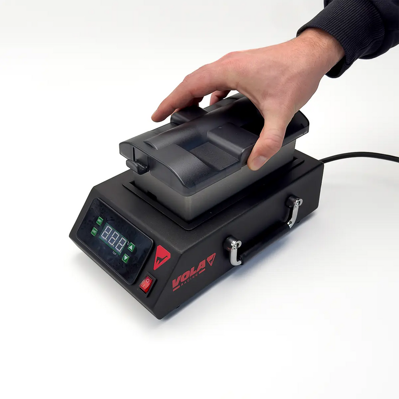 Chargez l'image dans le visualiseur de galerie, Wachsmaschine in schwarz mit rotem VOLA Logo und Digitalanzeige. Eine Hand hebt die Wachsschale heraus.