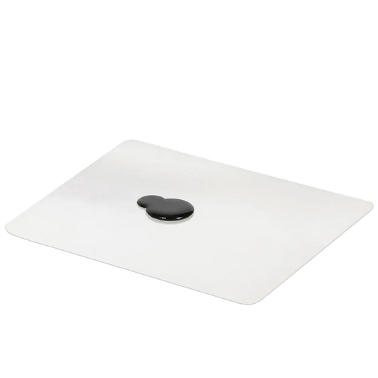 Quadratische weiße Matte mit einer schwarzen, tropfenförmigen Flüssigkeit in der Mitte.