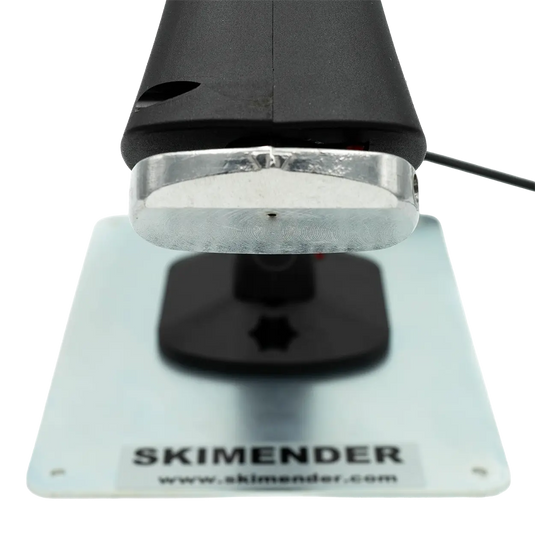 Nahaufnahme einer Düse eine Heißklebe-/ Reparaturpistolendüse mit rechteckiger Metallplatte und schwarzem Griff.